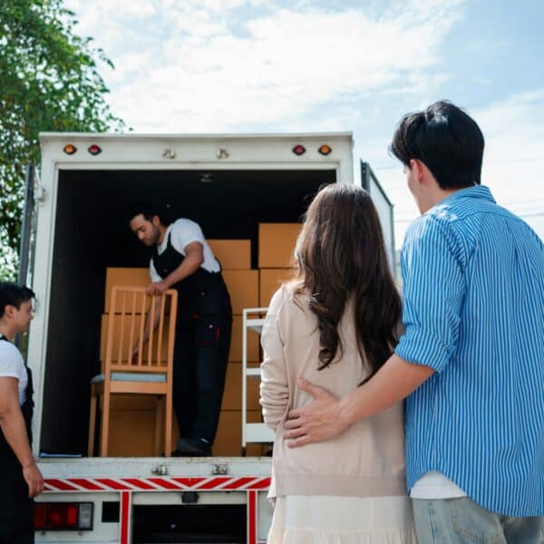 Asian Couple check while unloading boxes and furniture from a pickup truck