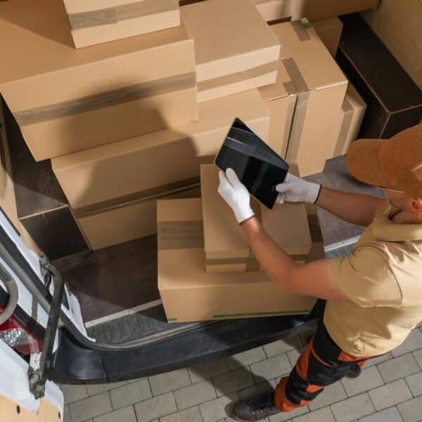 Courier Unloading Shipping Boxes From Truck